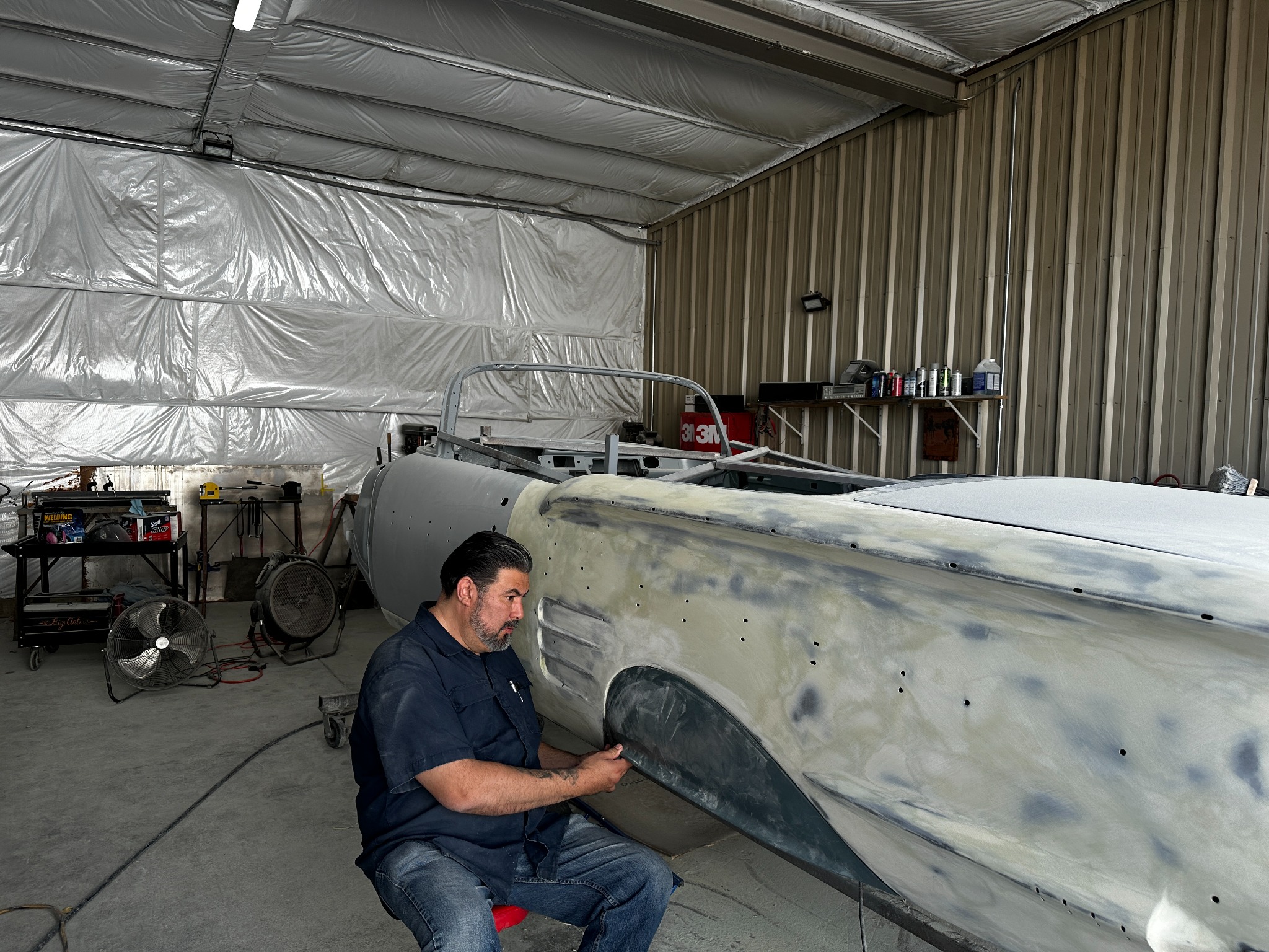 Anthony Cordova working on the side of a 1958 Impala convertible